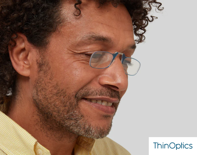 A smiling man wearing ThinOptics reading glasses.