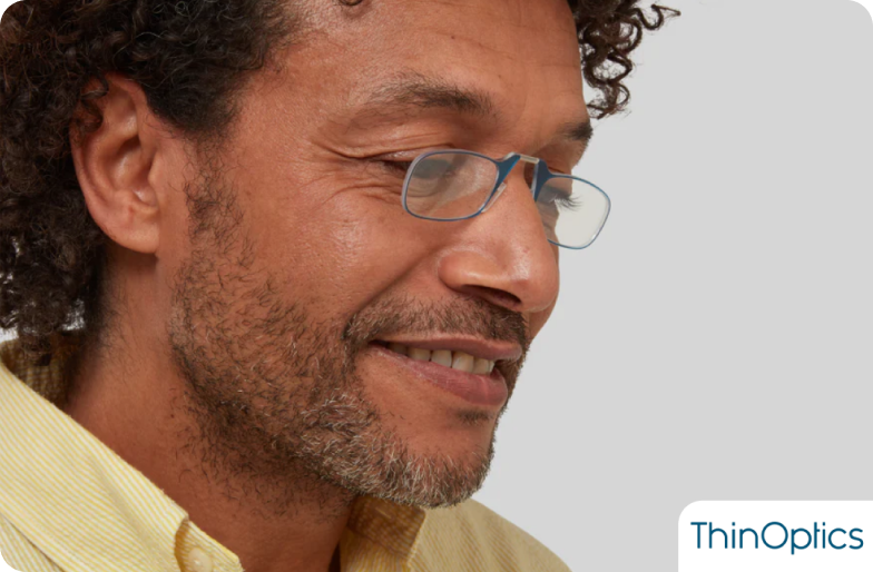 A smiling man wearing ThinOptics reading glasses